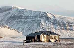 Svalbard Prints: Hunter's cabin with snowy mountains behind, Skansbukta, Billefjorden, Svalbard, Norway