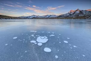 Ice bubbles on the frozen surface of Andossi Lake at sunrise Spluga Valley Valtellina