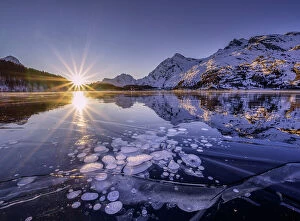 Images Dated 1st June 2023: Ice bubbles trapped in the frozen Lake Sils, during a sunsetcanton of Graubunden, Engadine