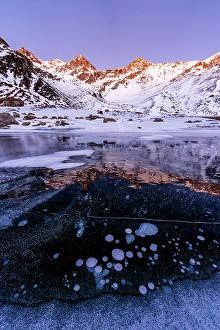 Circle Prints: Ice bubbles trapped in lake Montespluga at night