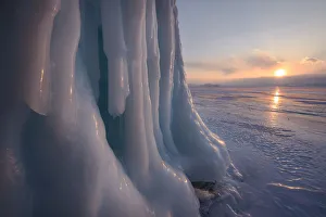 Ice stalactites in a cave at the shore at sunset at lake Baikal, Irkutsk region, Siberia