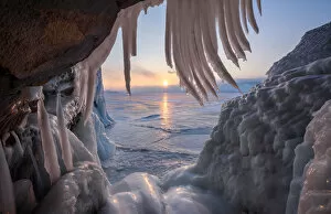 Solitude Gallery: Ice stalactites in a cave at the shore at sunset at lake Baikal, Irkutsk region, Siberia