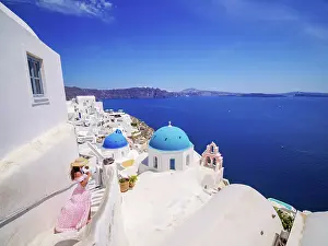 Iconic blue domed churches of Resurrection of the Lord and Saint Spyridon, elevated view, Oia Village, Santorini or Thira Island, Cyclades, Greece