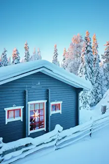 Ruka Prints: An idyllic hut covered with snow in a forest near Ruka during winter in finnish Lapland