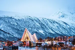 Fjord Prints: Illuminated Arctic Cathedral surrounded by snowcapped mountains at dusk, Tromso, Norway