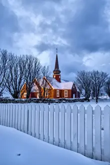 Lofoten Prints: The illuminated church at dusk in the cold snowy landscape at Flakstad Lofoten Norway