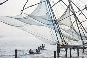 Images Dated 30th April 2020: India, Kerala, Cochin - Kochi, Fort Kochi, Fishermen in dug out canoes pass under Chinese