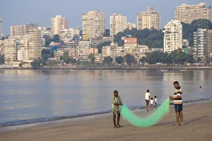 India, Maharashtra, Mumbai, Chowpatty, Men with fishing net on beach