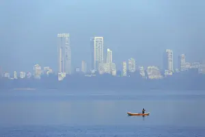India, Maharashtra, Mumbai, a fisherman in a traditional boat fishing off Nariman Point