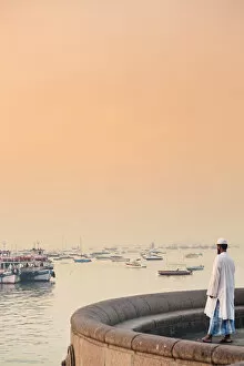 India, Maharashtra, Mumbai, a Muslim man watching sunrise over Mumbai harbour