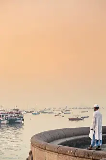 Bombay Prints: India, Maharashtra, Mumbai, a Muslim man watching sunrise over Mumbai harbour