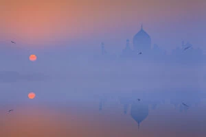 Agra Gallery: India, Taj Mahal memorial on a foggy morning with the sun rising in the background