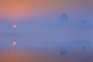 India, Taj Mahal memorial on a foggy morning with the sun rising in the background India, Taj Mahal memorial on a foggy morning with the sun rising in the background