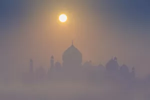 Images Dated 5th April 2018: India, Taj Mahal memorial on a foggy morning with the sun rising in the background