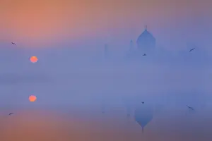 Agra Prints: India, Taj Mahal memorial on a foggy morning with the sun rising in the background