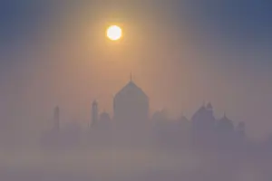 India, Taj Mahal memorial on a foggy morning with the sun rising in the background