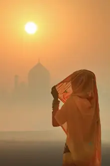 Agra Prints: India, woman wearing a traditional sari on a foggy morning with the Taj Mahal in