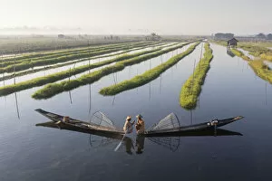 Two Intha fishermen meet in floating gardens on Inle Lake, Shan State, Myanmar