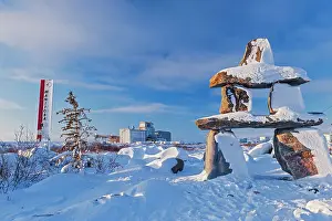 Inukshuk and Grain Terminal on shore of Hudson Bay in Churchill, Polar Bear Capital of the World. Churchill, Manitoba, Canada