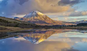 Ireland, Co. Donegal, Snow capped Errigal mountain reflected in Clady river at dusk