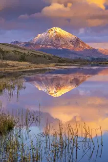 Ireland, Co. Donegal, Snow capped Errigal mountain reflected in Clady river at dusk