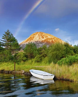 Ireland, Co.Donegal, Boat in lake infront of Mount Errigal with rainbow