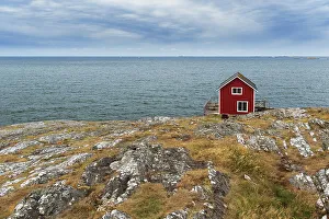 Scandinavian Culture Prints: Isolated red house overlooking the ocean