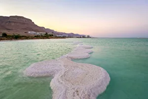 Israel, South District, Ein Bokek. Salt formations on the Dead Sea at sunset, town