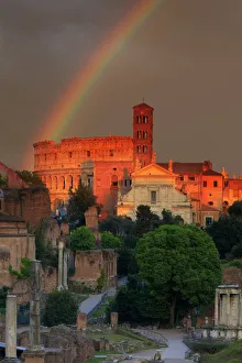 Italy, Rome, rainbow over Colosseum and Roman Forum at sunset