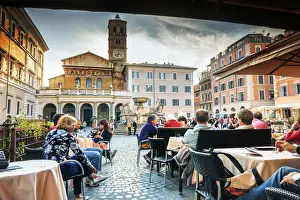 Italy, Rome, tourists having lunch in a restaurant in front of Santa Maria in Trastevere