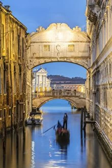 Tourists Gallery: Italy, Veneto, Venice. Bridge of sighs illuminated at dusk with gondolas