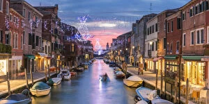 Romantic Gallery: Italy, Veneto, Venice, Murano island. Canal at sunset with Christmas lights hanging