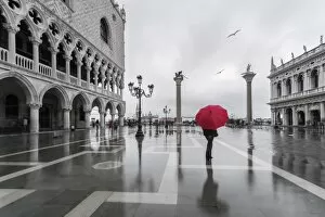 Venice Gallery: Italy, Veneto, Venice. Woman with red umbrella in front of Doges palace with acqua alta
