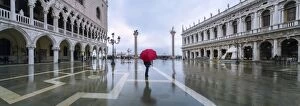 Acqua Alta Gallery: Italy, Veneto, Venice. Woman with red umbrella in front of Doges palace with acqua alta