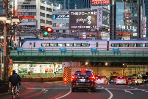 Automobile Prints: Japan, Tokyo, Train passing over road with cars and cyclist at dusk