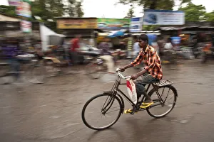 Jessore, Bangladesh. A man cycles to work through the centre of town Jessore, Bangladesh. A man cycles to work through the centre of town