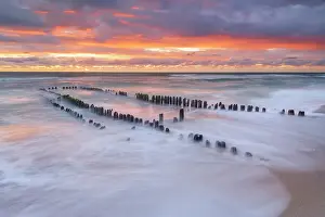 North Atlantic Ocean Prints: Jetty at a beach at Sylt Island with sunbeams during golden hour in the afternoon