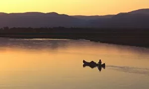Zambia Gallery: John Stevens paddling canoe on Zambezi from mana Pools