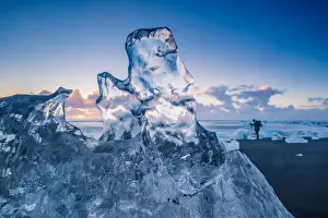 Photographer Prints: Jokulsarlon, Iceland. A transparent block of ice and a photographer on