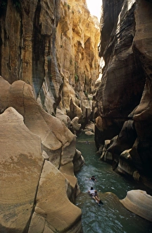 Jordan, Mujib Nature Reserve, Malaqi Trail, Hidan River. Canyoning walkers swim a stretch of the slender Hidan River Jordan, Mujib Nature Reserve, Malaqi Trail, Hidan River. Canyoning walkers swim a stretch of the slender Hidan River