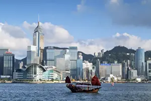 Junk boat passing Convention Centre and Hong Kong Island skyline, Hong Kong, China