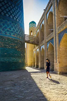Silk Road Gallery: Kalta Minor minaret, Khiva. Uzbekistan, Central Asia. Woman walking near the minaret