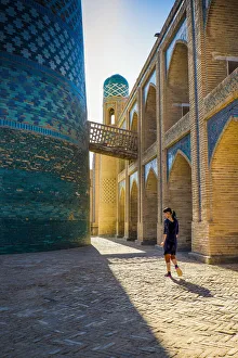 Central Gallery: Kalta Minor minaret, Khiva. Uzbekistan, Central Asia. Woman walking near the minaret