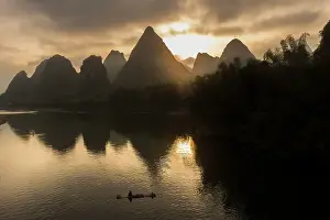 Guangxi Prints: Karst mountains and bamboo fishing raft on Li River at sunrise, Yangshuo, China