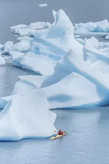 Kayaker paddling among icebergs, Torres del Paine National Park, Patagonia, Chile