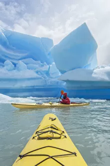 Kayaker paddling near icebergs, Torres del Paine National Park, Chile, MR