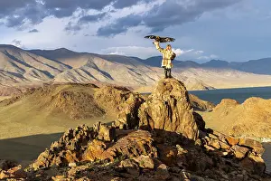 Mongolia Prints: Kazakh Eagle Hunter wearing traditional fur clothing and posing with his trained golden eagle
