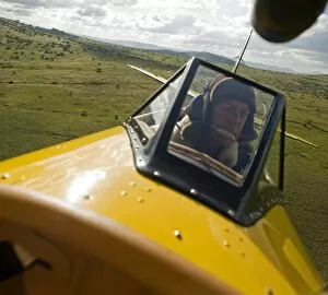Kenyan Collection: Kenya, Laikipia, Lewa Downs. Will Craig flies his 1930s style Waco Classic open cockpit bi-plane