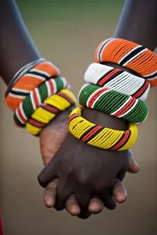Jewellery Collection: Kenya, Laikipia, Ol Malo. A Samburu boy and girl hold hands at a dance in their local manyatta