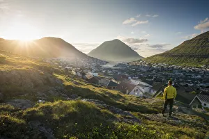 Faroese Prints: Klaksvik, Bordoy island, Faroe Islands, Denmark. Man watching the city at sunset. (MR)